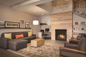 a living room with a couch and a fireplace at Country Inn & Suites by Radisson, Brooklyn Center, MN in Brooklyn Center