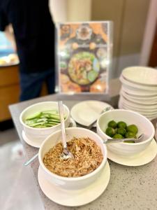 una mesa con tazones de comida y platos de comida en King Park Hotel Kota Kinabalu, en Kota Kinabalu