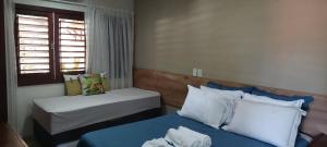 ein kleines Zimmer mit 2 Betten und einem Fenster in der Unterkunft Apartamento PIPA - UF01 dentro de Condominio Pipa Park in Pipa