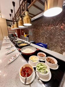 a buffet line with bowls of food on a counter at King Park Hotel Kota Kinabalu in Kota Kinabalu