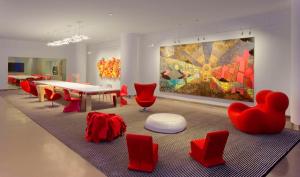 une chambre avec des chaises rouges, une table et un tableau dans l'établissement Radisson Blu Mall of America, à Bloomington