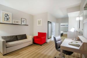 een woonkamer met een bank en een rode stoel bij Country Inn & Suites by Radisson, Columbia, MO in Columbia