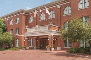 a red brick building with two flags in front of it at Country Inn & Suites by Radisson, St Charles Historic District in St. Charles
