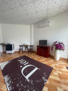 Zimmer mit einem Teppich auf einem Holzboden und einem Tisch in der Unterkunft Tân Thành Resort in Kê Gà
