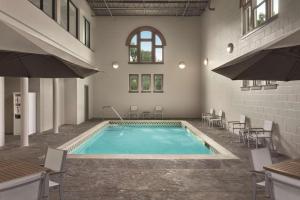 a swimming pool in a building with tables and chairs at Country Inn & Suites by Radisson, St. Charles, MO in St. Charles