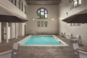 una piscina en un edificio con mesas y sillas en Country Inn & Suites by Radisson, St. Charles, MO en St. Charles