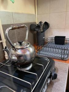 a tea pot sitting on top of a stove at Alojamiento ¨El Puente¨ en El Bolsón, para dos personas. in El Bolsón
