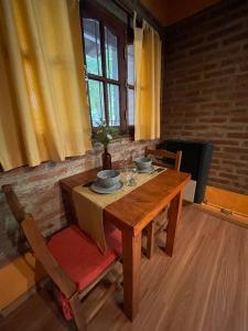 a wooden table with two bowls on top of it at Alojamiento ¨El Puente¨ en El Bolsón, para dos personas. in El Bolsón