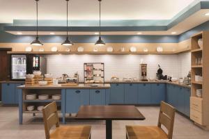拜勒姆的住宿－Country Inn & Suites by Radisson, Byram/Jackson South, MS，一间设有蓝色橱柜和一张桌子的大厨房