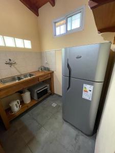 a kitchen with a stainless steel refrigerator and a sink at Alojamiento ¨El Puente¨ en El Bolsón, para dos personas. in El Bolsón