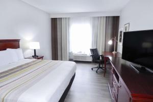 a hotel room with a bed and a flat screen tv at Country Inn & Suites by Radisson, Biloxi-Ocean Springs, MS in Ocean Springs