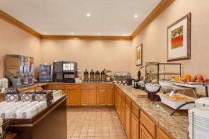 a large kitchen with a counter top with food at Country Inn & Suites by Radisson, Biloxi-Ocean Springs, MS in Ocean Springs