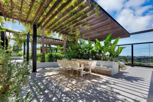 a patio with a table and chairs under a pergola at Central Location! Boutique 2BR Apartment with Pool & BBQ near South Bank and City in Brisbane