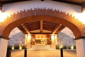 un accès à un bâtiment doté d'un grand mur en briques dans l'établissement Radisson Hotel Tapatio Guadalajara, à Guadalajara