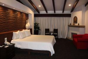 um quarto de hotel com uma cama e um sofá vermelho em Radisson Hotel Tapatio Guadalajara em Guadalajara