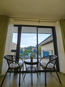 two chairs and a table in front of a window at Xtu Golf Villa Forest City二房独栋别墅 in Gelang Patah