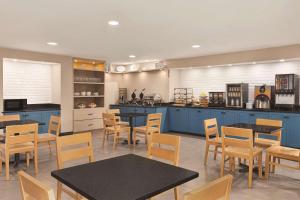 restauracja z niebieskimi szafkami, stołami i krzesłami w obiekcie Country Inn & Suites by Radisson, Dunn, NC w mieście Dunn