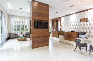 uma sala de estar com uma grande parede de madeira e uma televisão em Alto Padrão com Luxo e Conforto nas Alturas em São Paulo