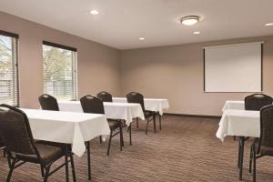 einen Konferenzraum mit Tischen, Stühlen und einem Whiteboard in der Unterkunft Country Inn & Suites by Radisson, Dunn, NC in Dunn