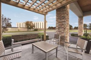 un patio avec un banc et des chaises et un bâtiment dans l'établissement Country Inn & Suites by Radisson, Dunn, NC, à Dunn