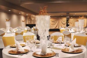 een kamer met witte tafels en stoelen en een grote kroonluchter bij Radisson Hotel Charlotte Airport in Charlotte