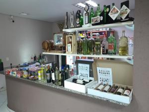 uma prateleira cheia de garrafas de álcool em Hotel e Restaurante São Cristovão 