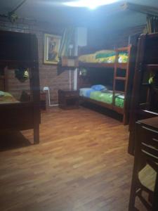 een slaapkamer met 2 stapelbedden en een houten vloer bij Hostal D´Mathias in Baños