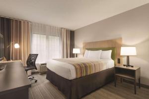 a hotel room with a bed and a desk at Country Inn & Suites by Radisson, Raleigh-Durham Airport, NC in Morrisville