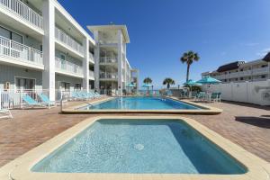 a swimming pool in front of a apartment building at Coastal Waters 106 - A 1-1 Pool Side Retreat in New Smyrna Beach