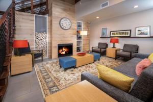 sala de estar con sofá y chimenea en Country Inn & Suites by Radisson, Rocky Mount, NC, en Rocky Mount