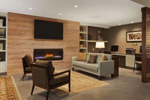 a living room with a fireplace with a tv on a wall at Country Inn & Suites by Radisson, Smithfield-Selma, NC in Smithfield