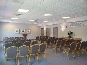 une salle de conférence avec des chaises et un podium dans l'établissement Country Inn & Suites by Radisson, Rocky Mount, NC, à Rocky Mount