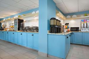 a large kitchen with blue cabinets and appliances at Country Inn & Suites by Radisson, Charlotte University Place, NC in Charlotte