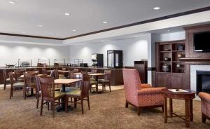 Habitación grande con mesas, sillas y bar. en Country Inn & Suites by Radisson, Concord (Kannapolis), NC, en Concord