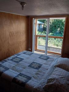 1 dormitorio con 1 cama frente a una ventana en Departamento centro de Puerto Montt, en Puerto Montt