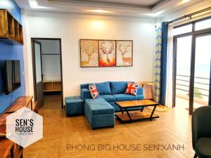 SenHomestay : غرفة معيشة مع أريكة زرقاء وطاولة