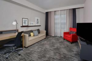 uma sala de estar com um sofá e uma cadeira vermelha em Country Inn & Suites by Radisson, Asheville West near Biltmore em Asheville