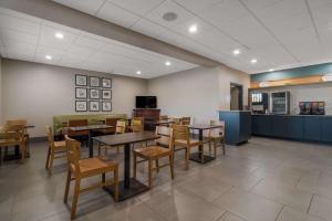 a dining room with tables and chairs and a kitchen at Country Inn & Suites by Radisson, Goldsboro, NC in Goldsboro