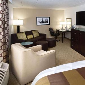 a living room with a couch and a table and a desk at Radisson Hotel Bismarck in Bismarck