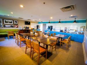 a restaurant with tables and chairs and a kitchen at Country Inn & Suites by Radisson, Burlington Elon , NC in Burlington