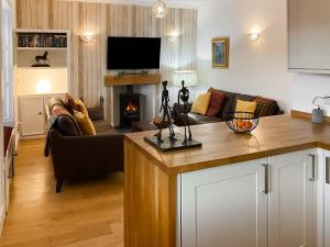 a living room with a couch and a fireplace at The Thistle in Auchtermuchty