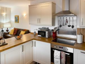 a kitchen with a counter top with a microwave at The Thistle in Auchtermuchty