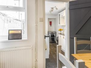 a kitchen and dining room with a table and a window at The Cottage in Gorleston-on-Sea