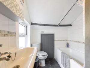 a bathroom with a tub and a toilet and a sink at The Cottage in Gorleston-on-Sea