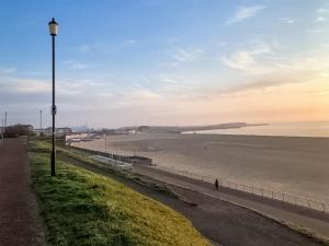 una luz de la calle en el lateral de una playa en The Cottage en Gorleston-on-Sea