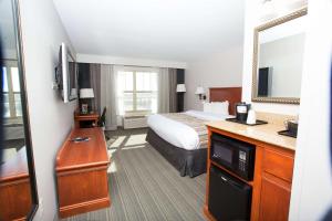 a hotel room with a bed and a mirror at Country Inn & Suites by Radisson, Grand Forks, ND in Grand Forks