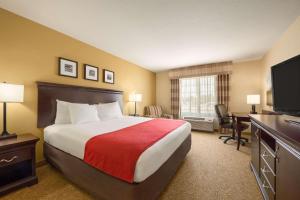 a hotel room with a bed and a flat screen tv at Country Inn & Suites by Radisson, Minot, ND in Minot +39 photos