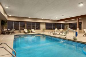 a pool at a hotel with chairs and tables at Country Inn & Suites by Radisson, Sidney, NE in Sidney