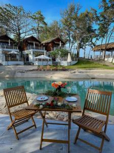 two chairs and a table in front of a pool at Resort Bai Xep Quy Nhon in Quy Nhon