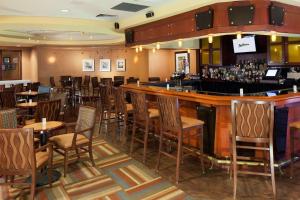 a bar in a restaurant with tables and chairs at Radisson Hotel JFK Airport in Queens